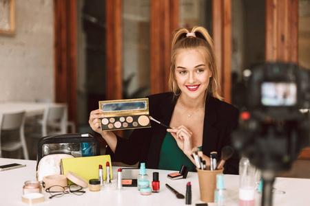 年轻漂亮的美丽的博客谈论化妆品产品录制新的视频沃客照片